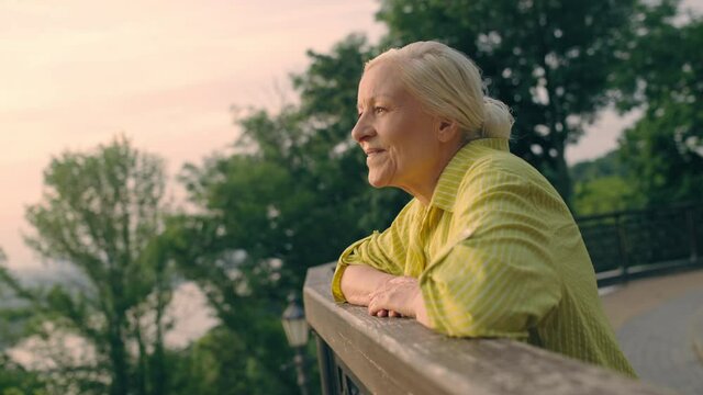 Happy senior woman enjoying city view in park, fresh, air, positive emotions