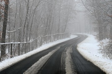 Obraz premium Bad weather driving - foggy hazy country road. Motorway - road traffic. Winter time and snow.