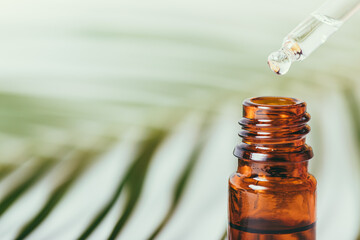 Essential oil drop dripping from pipette