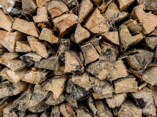 firewood cut, split into pieces and stacked as a background - obrazy, fototapety, plakaty