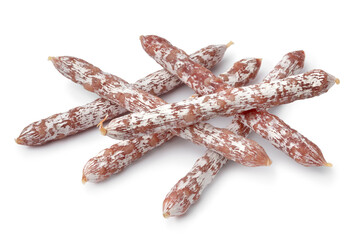 Heap of dry smoked salami sticks close up for a snack isolated on white background