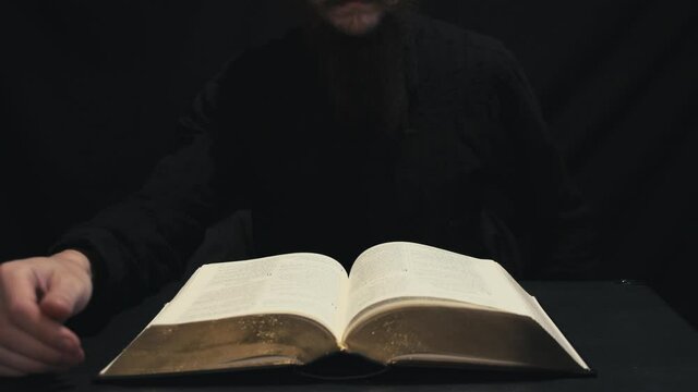 Christian pastor reading the Holy Bible. Hands turning pages