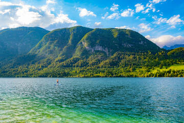 Moraine-dammed mountain lake Bohinji (Bohinjsko) in Slovenia, Europe with a tiny SUP boarder
