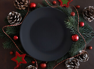 Ramo di albero di Natale, piatto vuoto, decorazione di Natale su sfondo scuro. Direttamente sopra....