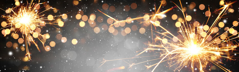 Happy New Year background with glowing sparklers.