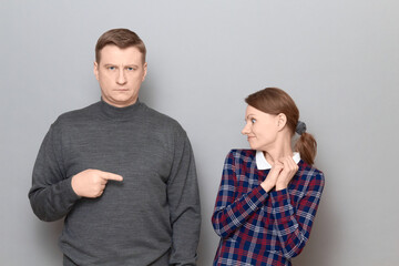 Shot of couple, man is pointing with index finger at woman