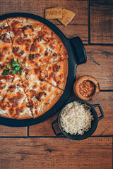 Buffalo chicken pizza pie on pizza stone with wooden background