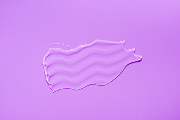 Cosmetic smear. Appearance of the texture of the transparent gel on purple background. Natural skincare products. Beauty concept for face and body care