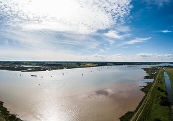 Small sailing boats out on the River Deben in Suffolk on a clear and warm summers day