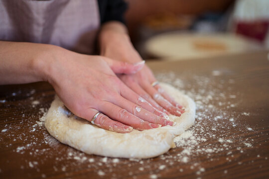 Anonymous woman kneading dough for pizza