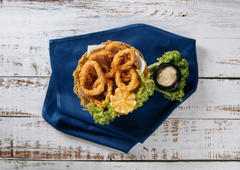 An appetizing plate of Oven baked breaded calamari rings served with lime wedges, sweet chilli sauce and mayonnaise.