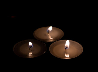 Lit candles. Dark background. Commemorative candles.