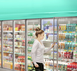 Woman choosing frozen food from a supermarket freezer.