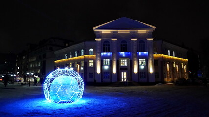 The city of Bryansk, Russia - December 30, 2021: a view of the illuminated building and a ball with...