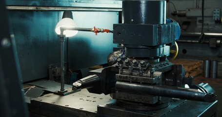 CNC type multipurpose lathe for drilling brass shaft. High-tech metal processing process with CNC lathe control.