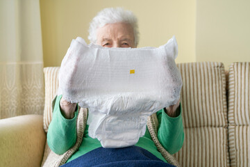 old senior woman or man holding white adult diaper pad - obrazy, fototapety, plakaty