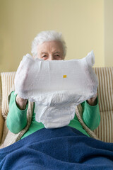 old woman or man holding white adult diaper pad