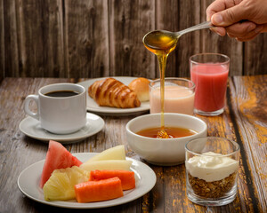 Breakfast table with emphasis on tropical fruits and bee honey.