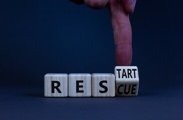 Rescue and restart symbol. Businessman turns a wooden cube and changes the word rescue to restart....