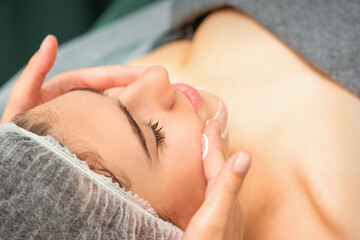 Obraz na płótnie Canvas Spa facial skincare. Close-up of a young caucasian woman getting spa moisturizing face massage treatment at beauty spa salon