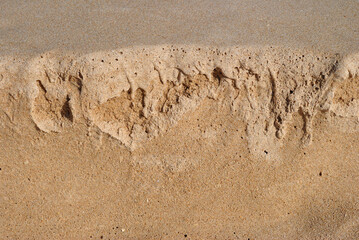 Fototapeta premium Close Up of Textured Eroded Sand on Sunny Beach 