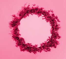 A delicate wreath made of dried mallow blooms neatly arranged in a circle on a purplish red background. Minimalist concept of love and appreciation. Copy space. Flat lay. Floral frame. Natural design.