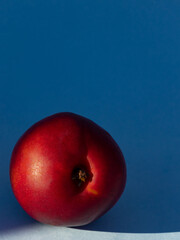 Durazno sobre fondo azul fotografía vertical / Peach on blue background vertical photo
