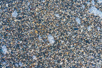 sea beach of small multi-colored pebbles as a natural background