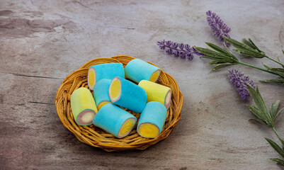 Fototapeta na wymiar Marshmallow dolci fatti alla lavanda su un piatto e fiori di lavanda sul tavolo della cucina.