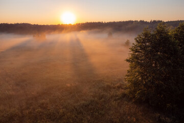 Sun illuminate morning mist in the valley. Early in the morning in summer season