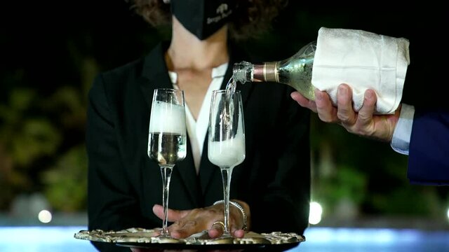 the maître pours champagne to celebrate the party
