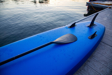 Close up view of a stand up paddle sitting on the edge of the lake