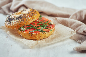 Bagel with salmon and arugula on a table