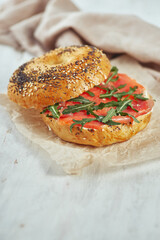 Bagel with salmon and arugula on a table