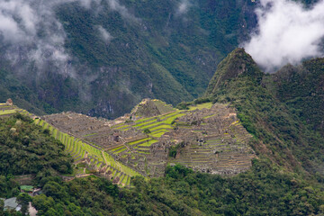 views of Macchu Picchu through the mist with clouds, Peru