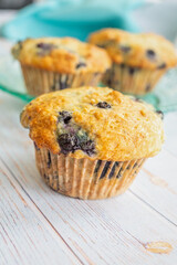 Homemade blueberry muffins on a teal glass plate.