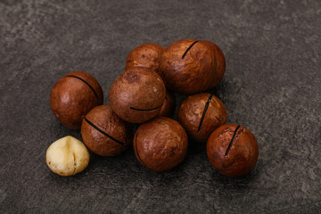 Brown macadamia nut heap over background