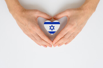 The national flag of Israel in female hands. The concept of patriotism, respect and solidarity with...