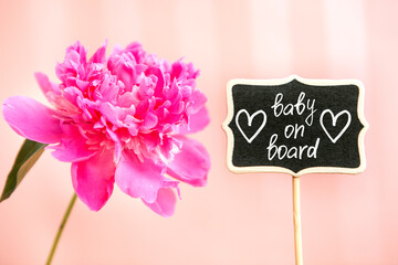Baby on board - colorful card with text and hearts on blackboard and pink peony flower