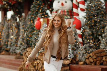 Young beautiful blonde woman with long hair near a big snowman