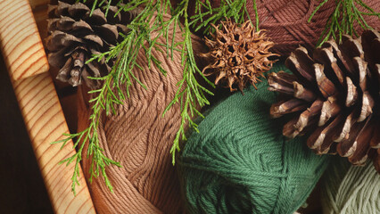 Skeins of Earthy Colored Yarn in a Wooden Basket with Gumballs, Pine Cones and Evergreen Branches | Rustic Yarn | Yarn Close-Up