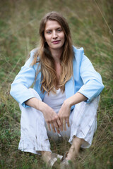 portrait of blond woman sitting outdoors in the grass