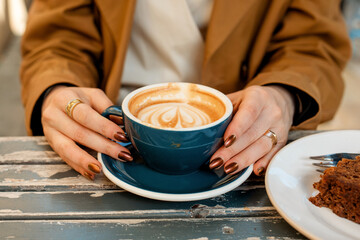 hands of woman holding cup of coffee in the cafe  