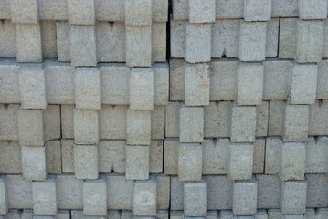 gray stone texture of a row of concrete slabs in the wall in the street