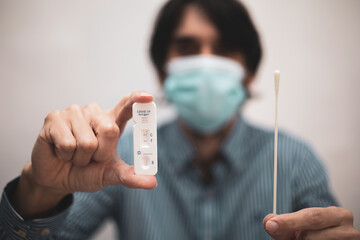 A man holds the rapid antigen test kit with positive result during the COVID-19 test. Omicron.