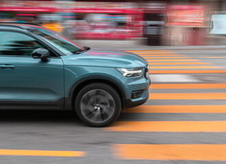 Fototapeta na wymiar The car drives quickly through a pedestrian crossing, the background contains motion blur