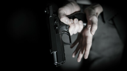 Man loading a 9mm pistol. Personal defense and concealed carry concept - obrazy, fototapety, plakaty