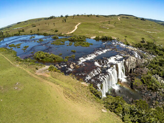 Aerial view of Waterfall with fields, rocks and dirty road