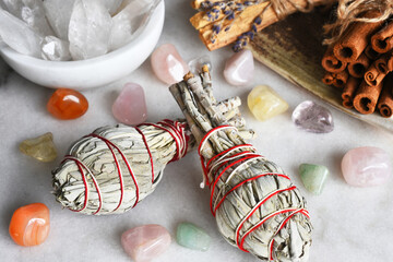 A top view image of two white sage smudge sticks with healing crystals. 
