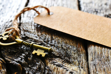 A close up image of an old vintage key with brown paper label attached. 